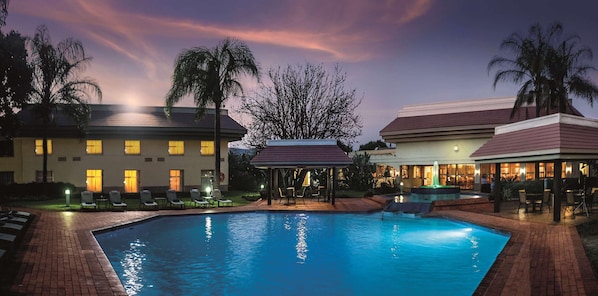 A hotel with a swimming pool, lounge chairs, and a gazebo. - Garden Court Ulundi (Ulundi)
