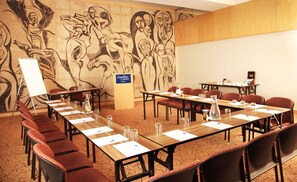 A conference room with a long table, chairs, and a whiteboard. A mural is on the wall behind the table. - Garden Court Ulundi (Ulundi)
