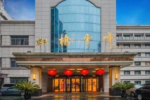 A hotel entrance with a modern glass facade and traditional Chinese characters above the doors. - Hongqiao Yunfeng Hotel (Shanghai)