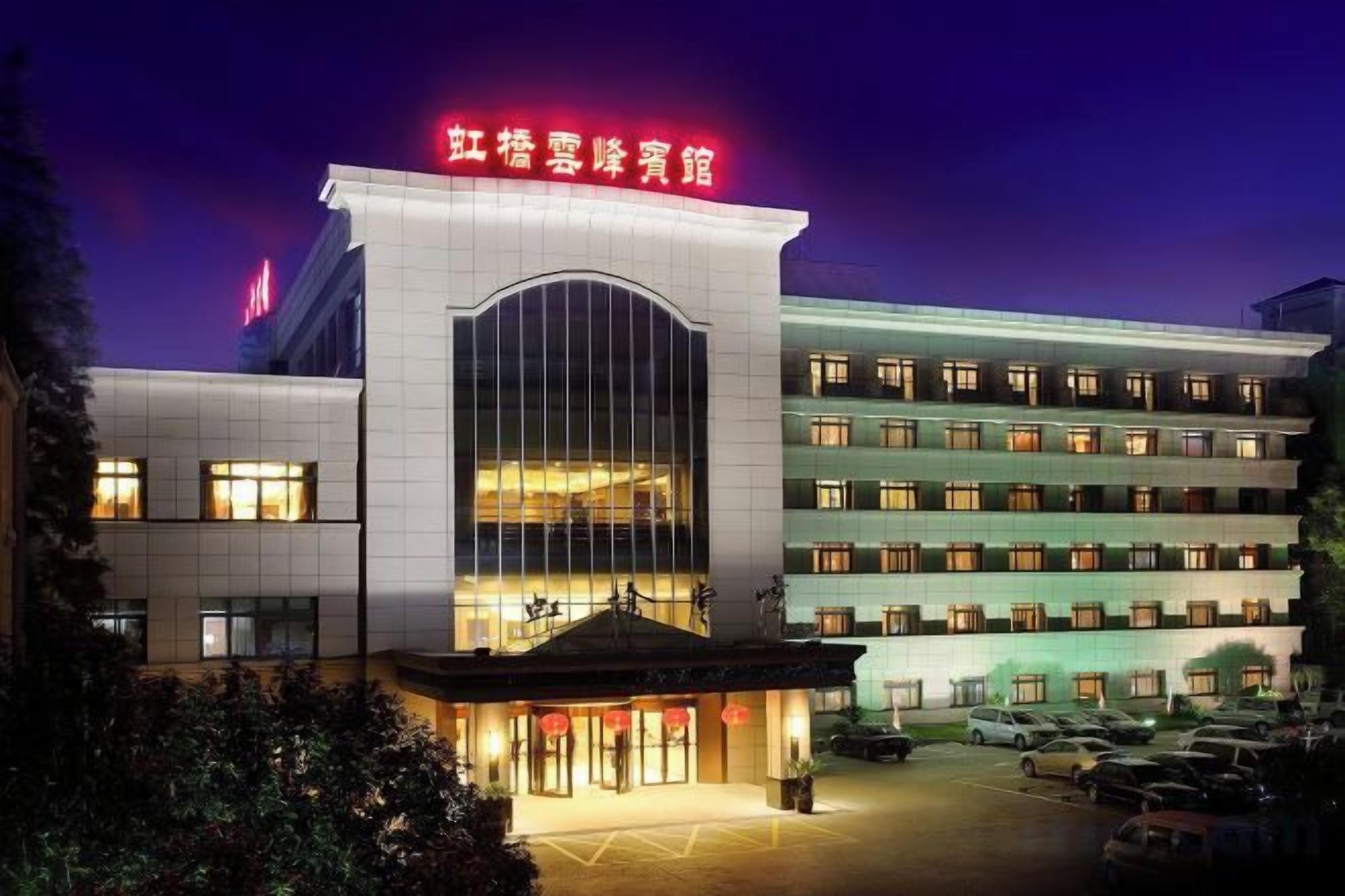 A multi-story hotel with a prominent entrance and a large arched window.