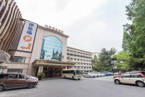 A hotel with a parking lot, a bus, and multiple cars. - Hongqiao Yunfeng Hotel (Shanghai)