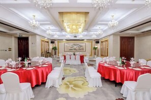 A conference room with round tables, white chairs, and red tablecloths. - Hongqiao Yunfeng Hotel (Shanghai)