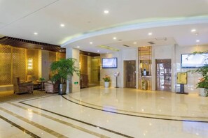 A hotel lobby with a curved ceiling, a reception desk, a television, and potted plants. - Hongqiao Yunfeng Hotel (Shanghai)