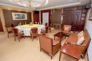 Una sala de conferencias con una mesa redonda, sillas, un sofá y una mesa de centro.