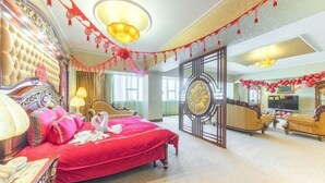 Une chambre d’hôtel dotée d’un grand lit, d’un coin salon avec des canapés et d’une télévision.