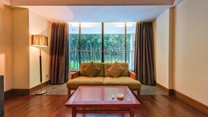 A room with a sofa, a table, and a lamp. - Jin Jiang Sanya Royal Garden Resort (Sanya)