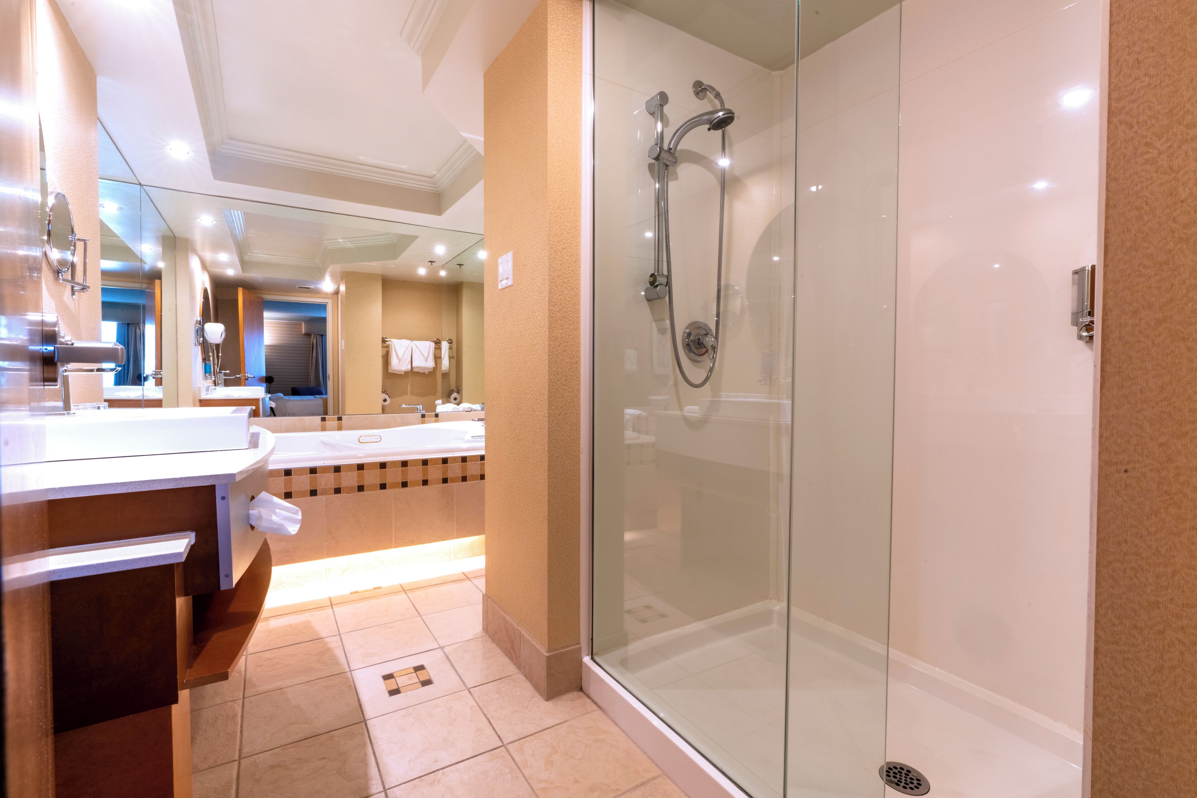 Une salle de bain moderne avec une douche à parois de verre, un meuble-lavabo avec un miroir et un évier.