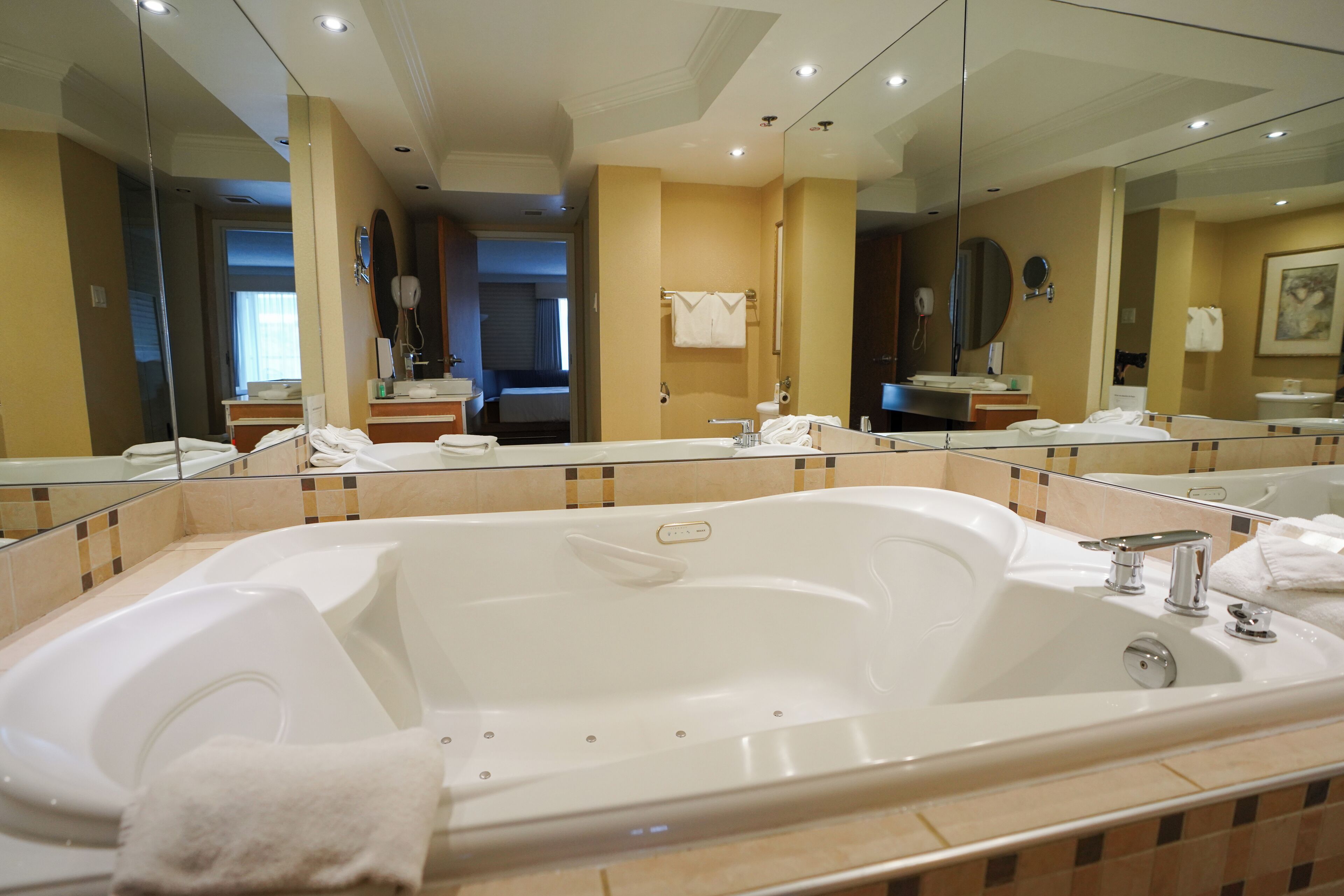 Un baño moderno con una bañera grande, una zona de ducha separada y un tocador con espejo.