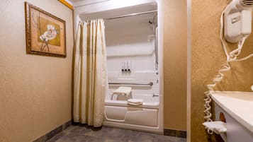 Un baño con bañera, ducha, secador de manos y toallero.