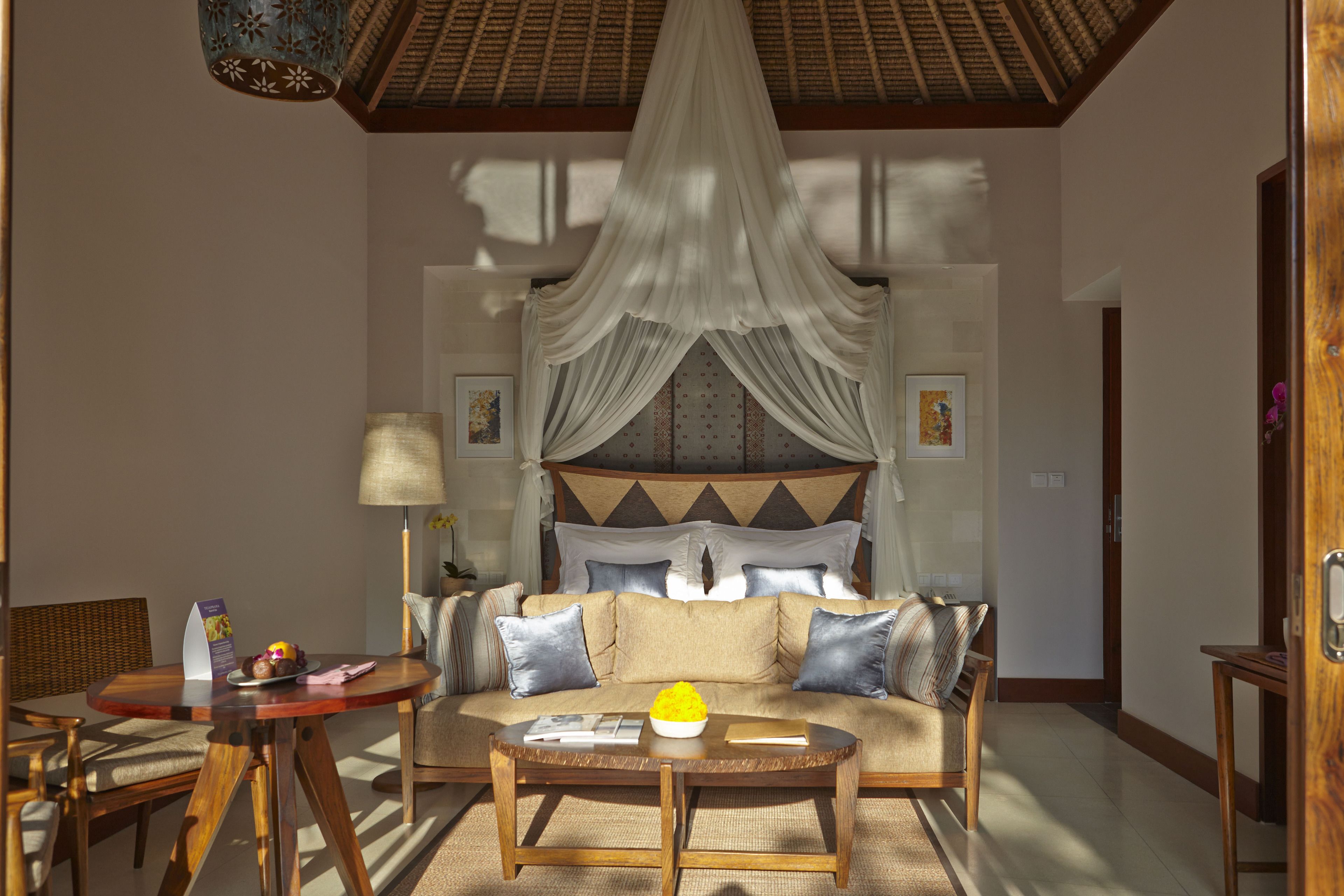 A room with a bed, a sofa, a coffee table, and a dining table.