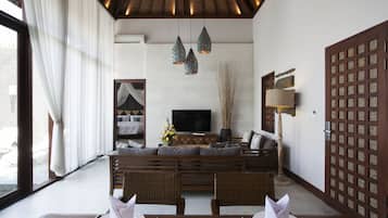 A modern living room with a sofa, dining table, and a TV.