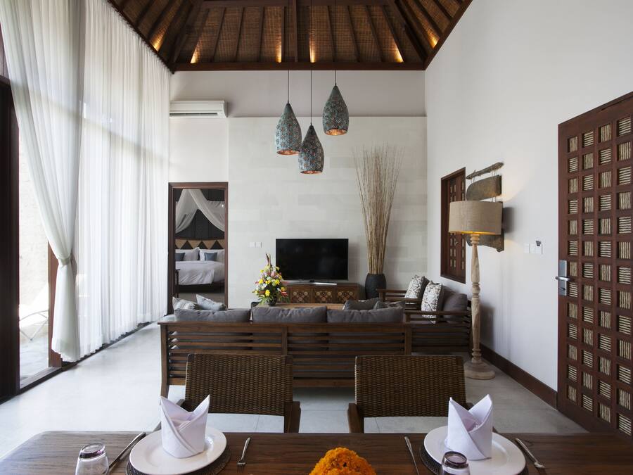 A modern living room with a sofa, dining table, and a TV.