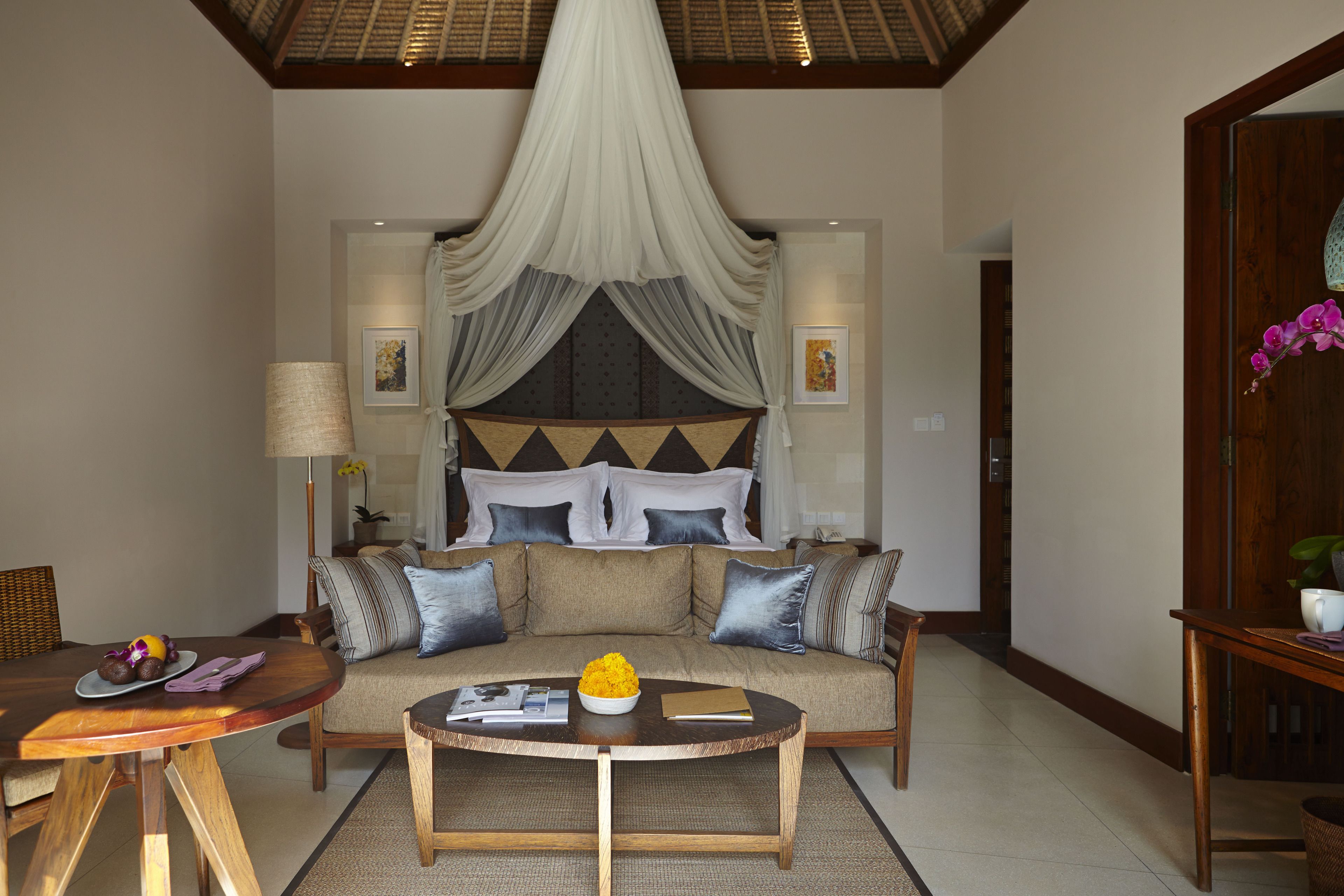 A spacious living area with a sofa, coffee table, and a dining table.