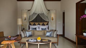 A spacious living area with a sofa, coffee table, and a dining table.