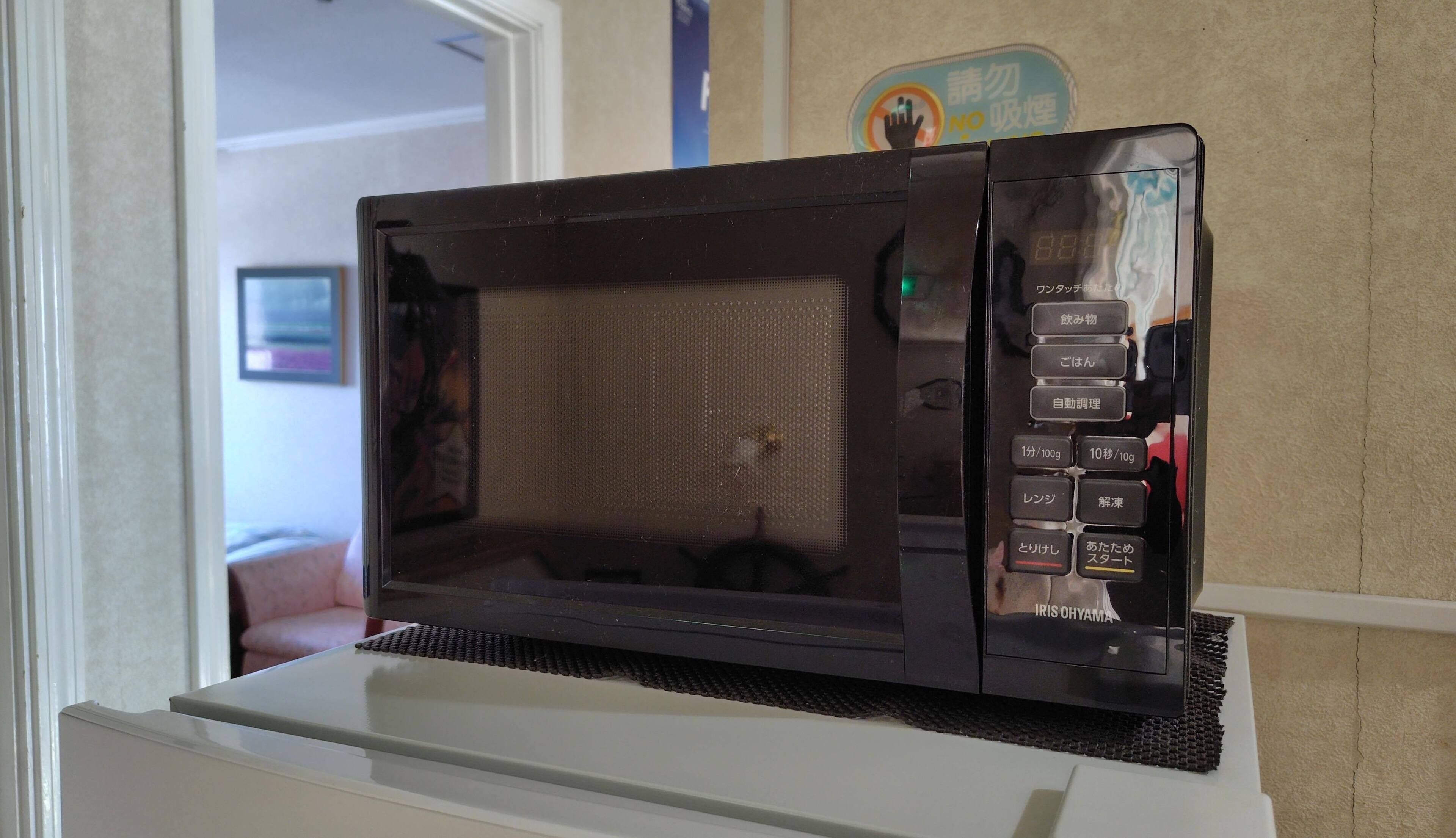 A black microwave on a white countertop.