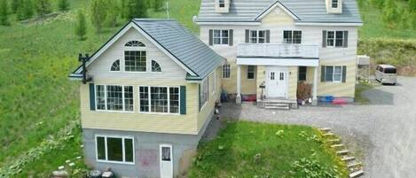 Une maison à deux étages avec un porche à l’avant et une allée.