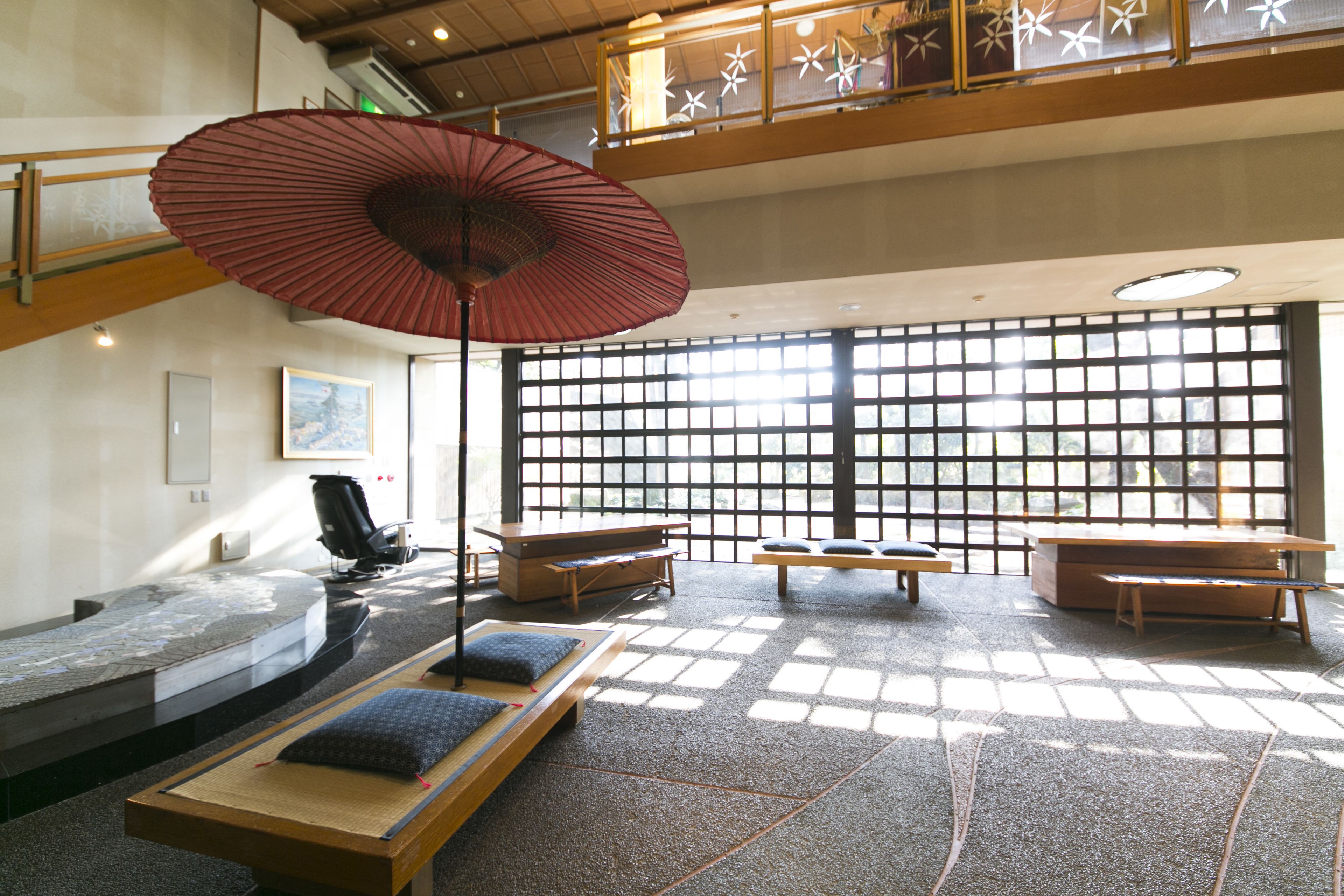 A traditional Japanese-style room with tatami mats, low wooden tables, and a large shoji screen.