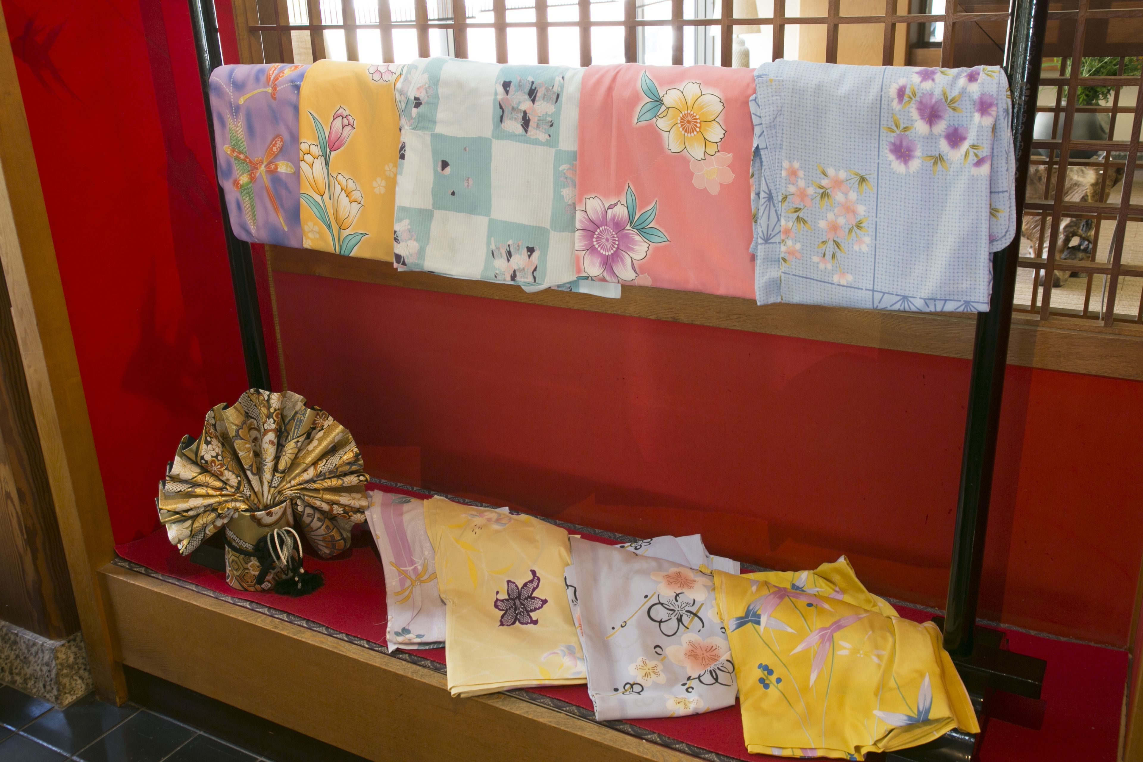 A display of folded textiles with floral patterns.