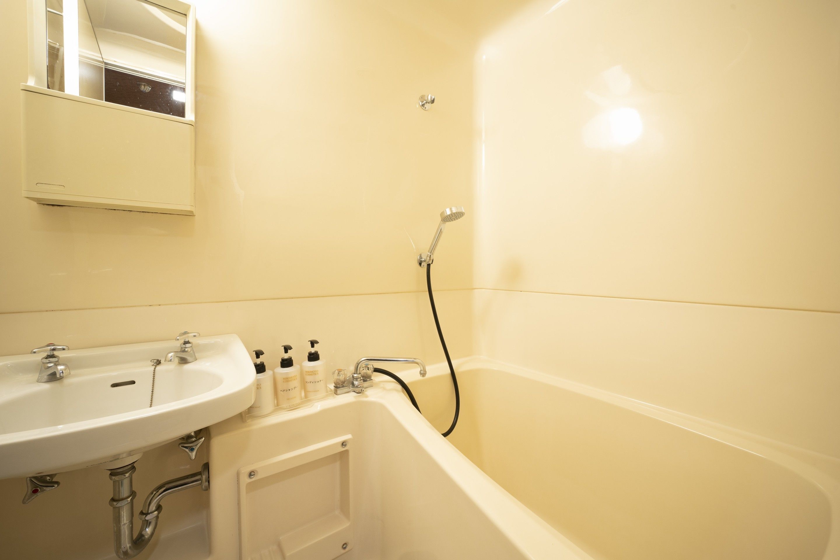 Une salle de bain avec un lavabo, un miroir et une baignoire.