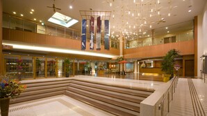 A spacious indoor area with a central staircase, multiple levels, and a ceiling fan. - Tsurugi Koizuki (Kamiichi)