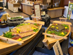 A buffet with various dishes arranged on wooden boards. - Tsurugi Koizuki (Kamiichi)