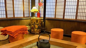 A traditional Japanese room with tatami flooring, a tea kettle, a lamp, and a decorative vase. - Hotel Sejour mint (Hakuba)