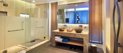 Een moderne badkamer met een douchecabine, een marmeren wastafelmeubel met een grote spiegel en een inbouwgootsteen.