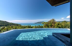 A infinity pool with a clear view of the ocean and hills. - Crest Resort & Pool Villas (Patong)