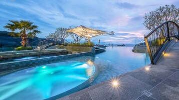 Una piscina al aire libre, sillones reclinables de piscina