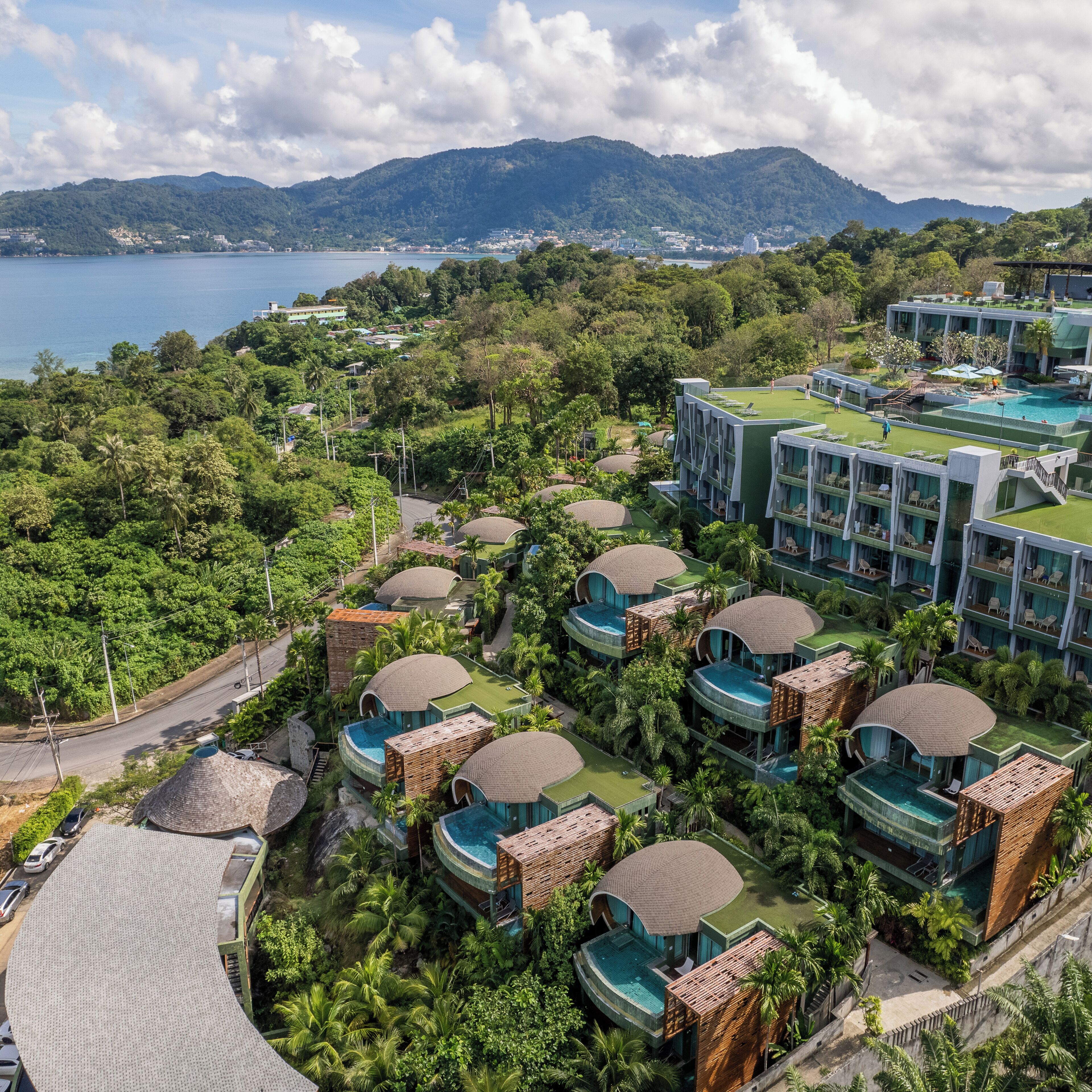 A resort with multiple bungalow-style buildings, each with a private pool and surrounded by lush greenery.
