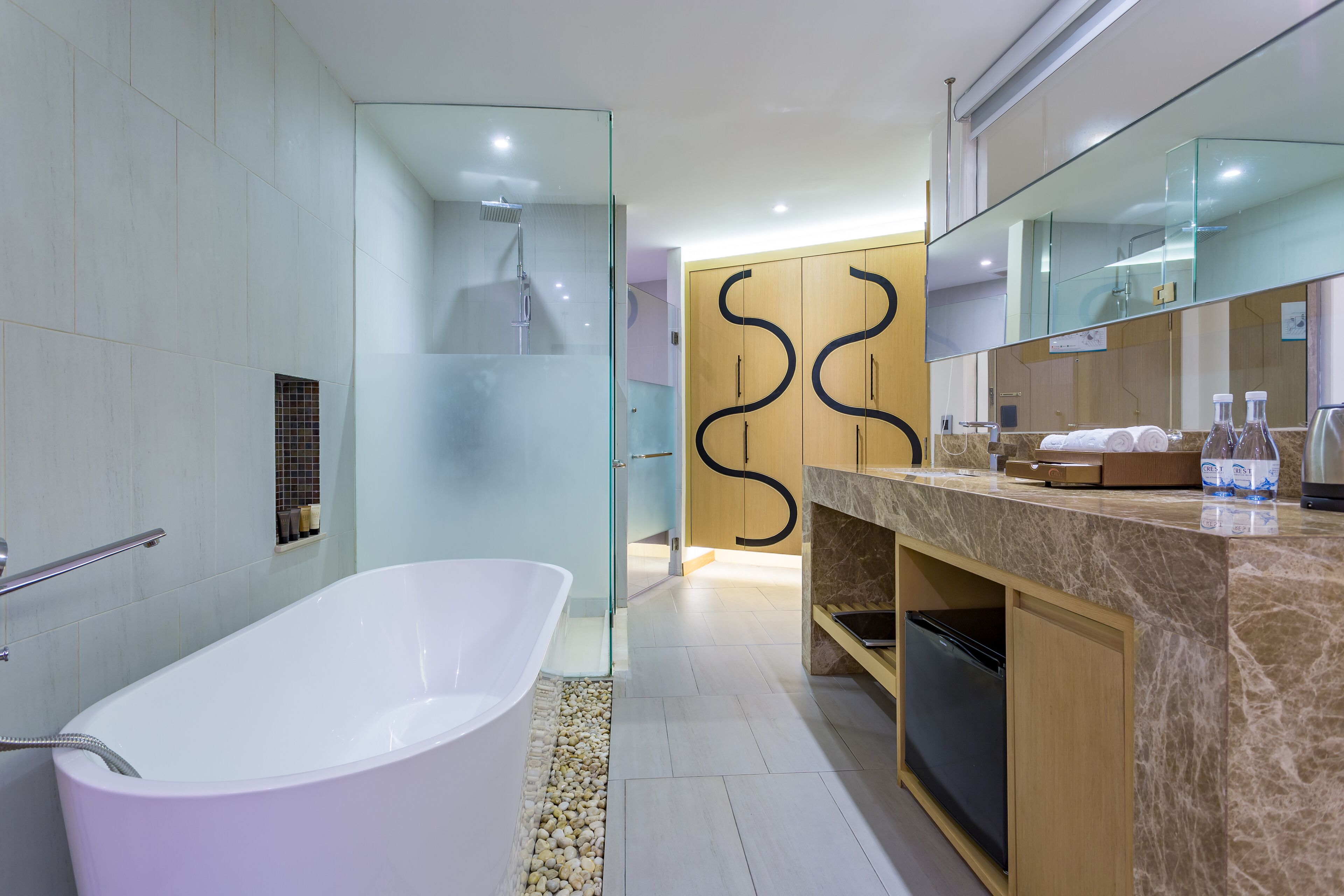 A modern bathroom with a freestanding bathtub, a glass-enclosed shower, and a vanity with a marble countertop.