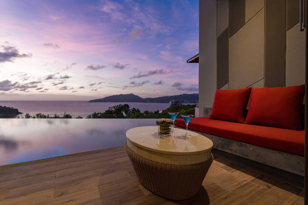Un espacio moderno de estar al aire libre con vistas al mar y a las montañas.