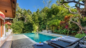 A poolside area with lounge chairs and a small pool, surrounded by lush greenery and a wooden structure. - The Tunjung Ubud Retreat (Ubud)