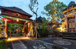 A traditional temple with a tiled roof, a stone pathway, and a statue of a deity. - The Tunjung Ubud Retreat (Ubud)