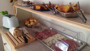 A buffet with various food items including bread, pastries, and deli meats. - Agriturismo Renai e Monte (Gambassi Terme)