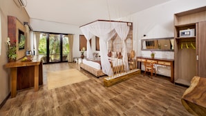 A bedroom with a four-poster bed, a desk, a chair, and a small table with a plant. - Arimba Resort Ubud (Ubud)