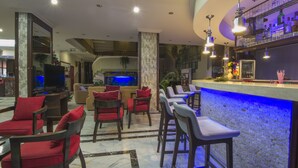 A lobby with a bar area, seating, and a television. - My Home Apart Hotel (Alanya)