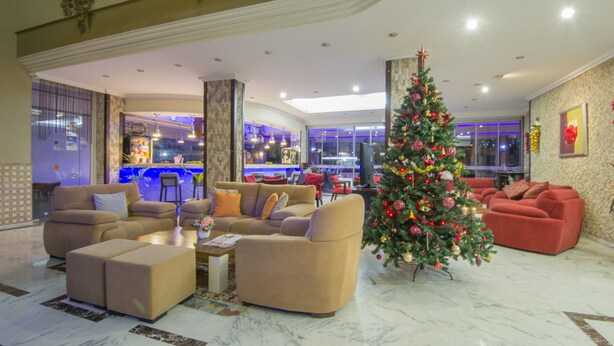 A spacious lobby with a large Christmas tree, comfortable seating, and a view of the bar area. - My Home Apart Hotel (Alanya)
