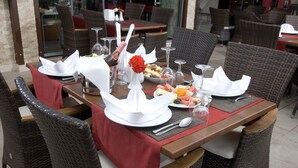 A dining table set with white napkins, wine glasses, and a bottle of champagne. - My Home Apart Hotel (Alanya)