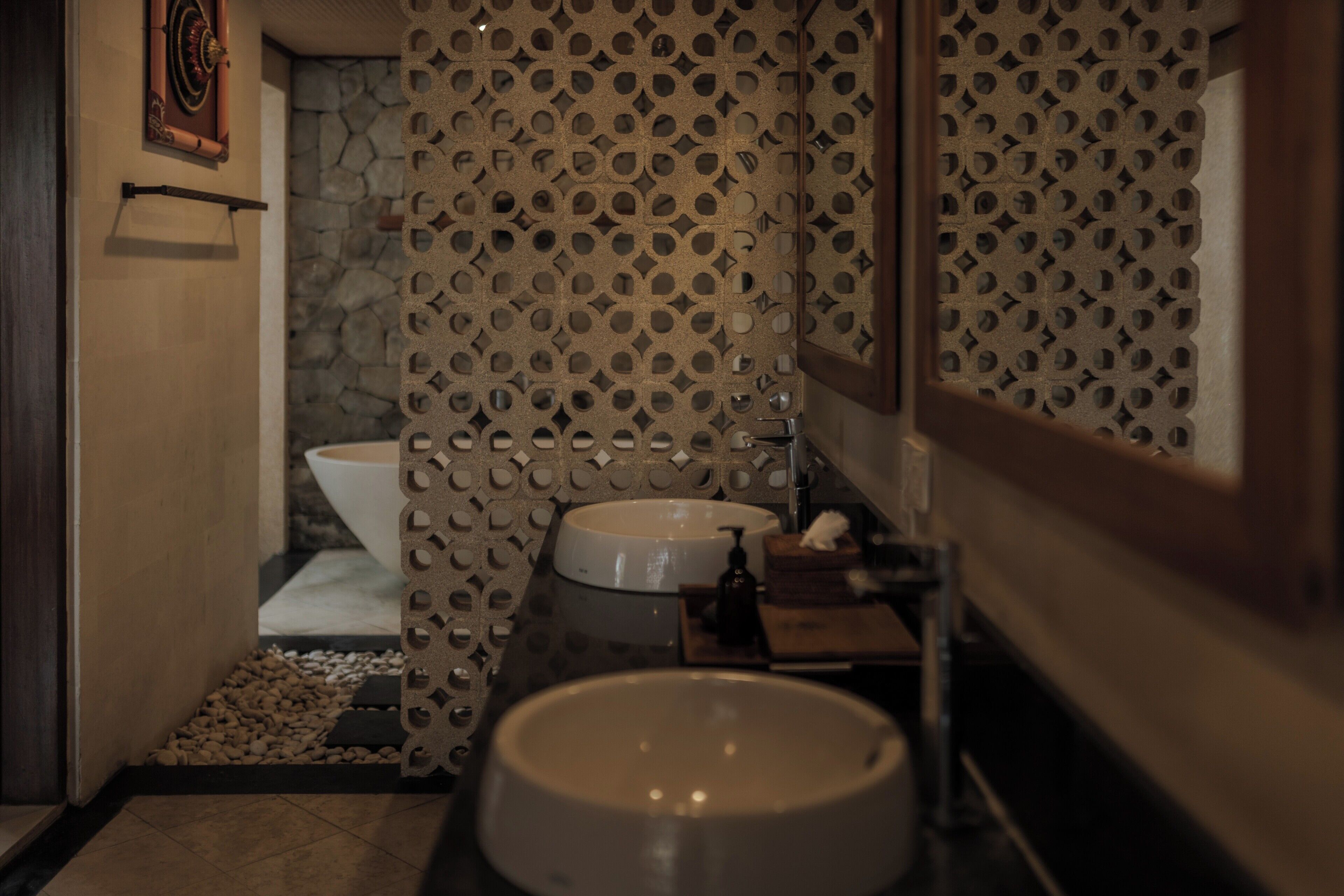 A bathroom with a sink, toilet, and decorative wall paneling.