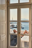 Ένα δωμάτιο με ένα μεγάλο παράθυρο που προσφέρει θέα σε μια μαρίνα γεμάτη σκάφη.