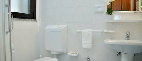 A bathroom with a toilet, bidet, and sink.