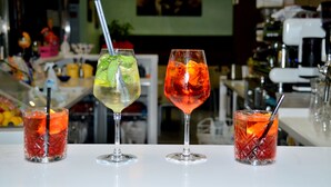 Drei Cocktails auf einer Bar, im Hintergrund verschwommen ein Restaurantinneres.
