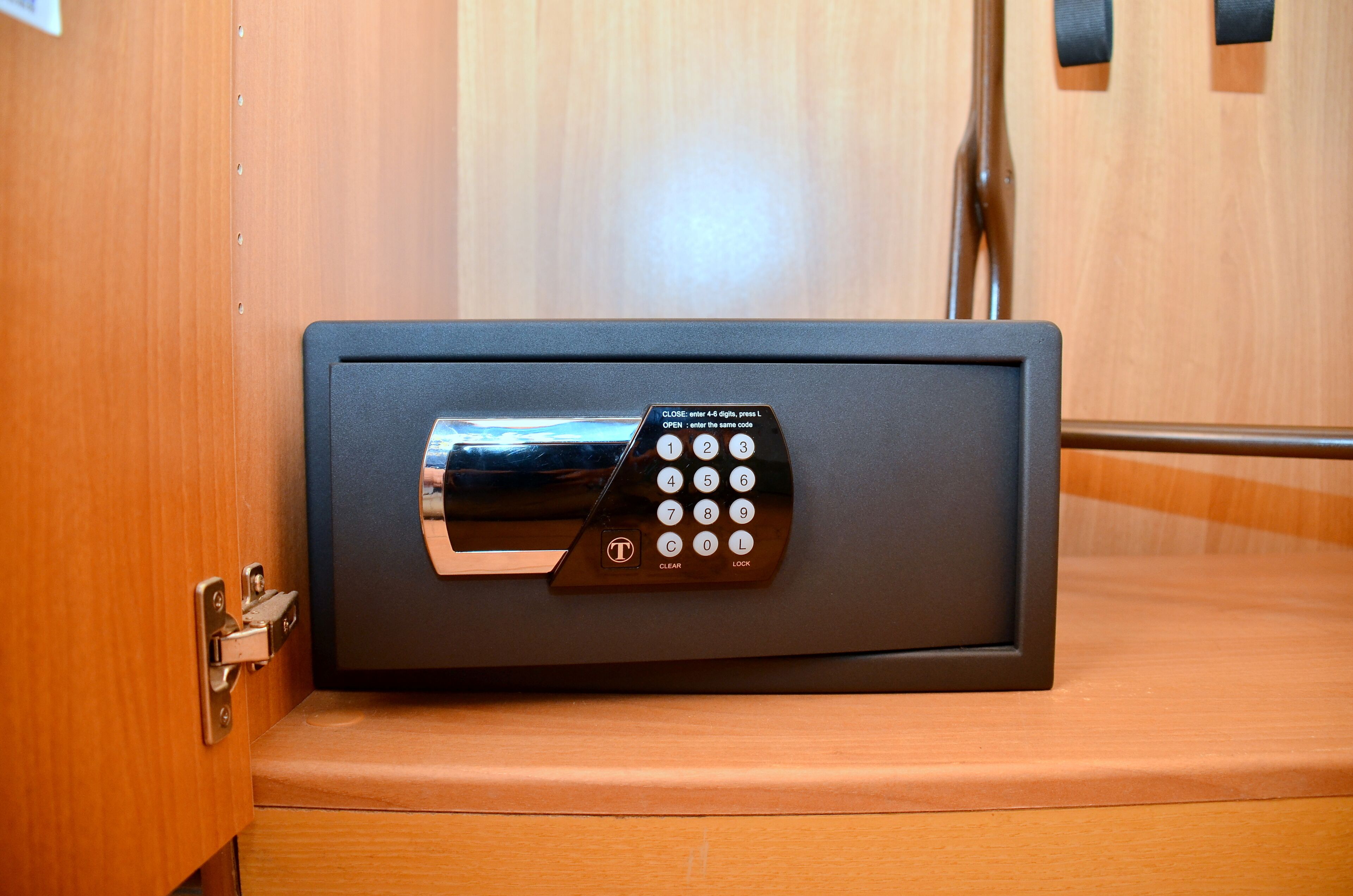 A safe with a keypad lock on a wooden surface.