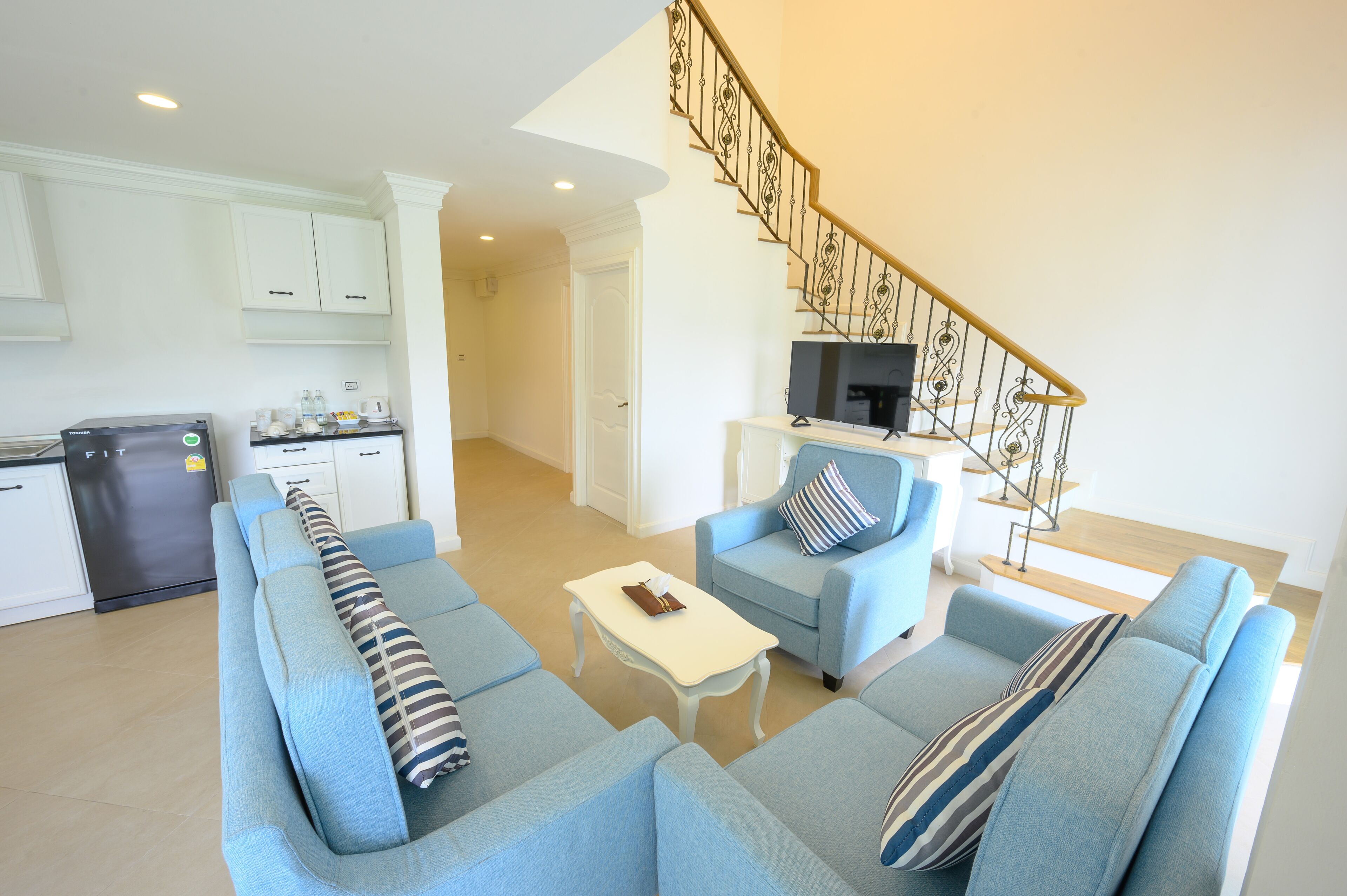 A modern living room with a sofa set, a coffee table, and a television.