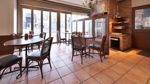 A restaurant with brick walls, large windows, and a brick fireplace. - APA Hotel Owariichinomiya Station (Ichinomiya)