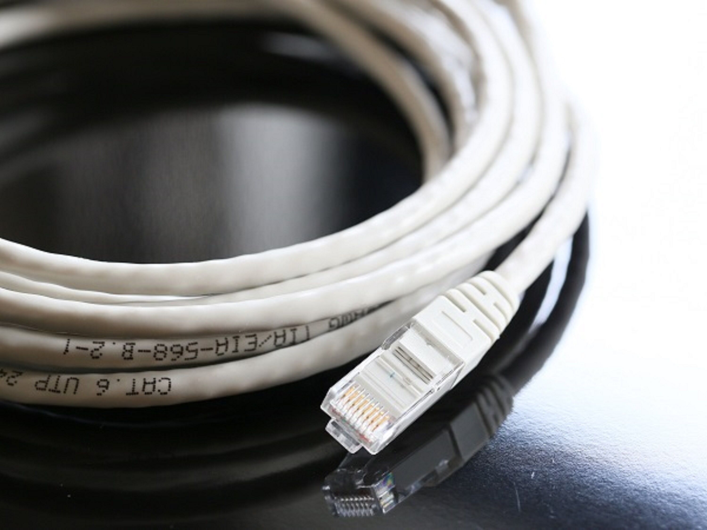 Un câble Ethernet enroulé, muni d’une étiquette indiquant qu’il s’agit d’un câble UTP de catégorie 5e.