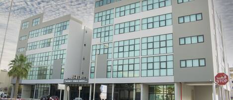 A modern hotel with multiple floors, large windows, and a prominent Infinity Tower Suites sign.