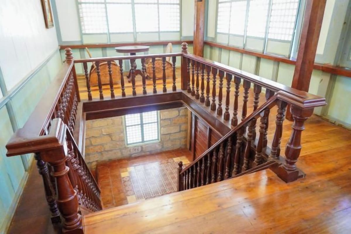 Eine Holztreppe mit Handlauf, die zu einer oberen Etage führt.