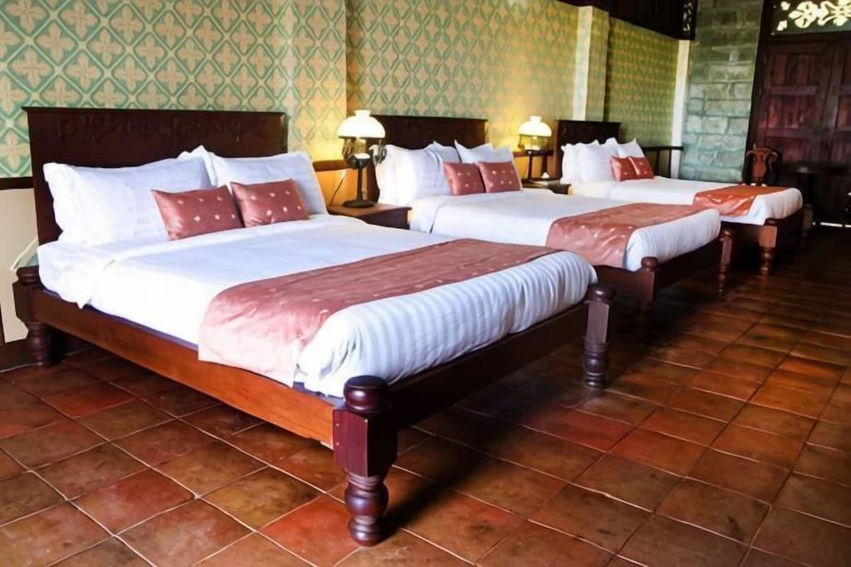 Une chambre d’hôtel avec deux lits, des têtes de lit en bois et un sol carrelé.